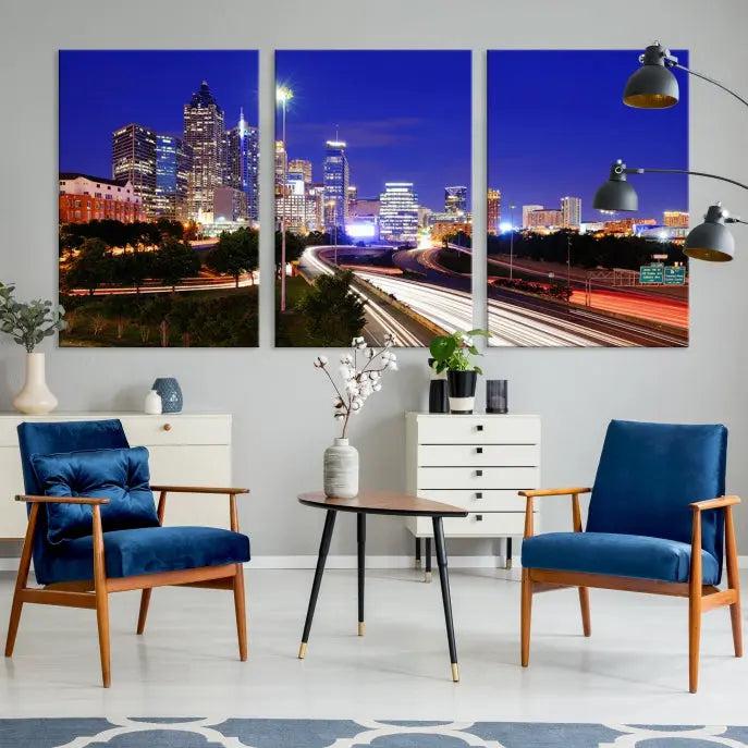 The living room features an Atlanta City Lights Night Blue Skyline canvas print on the wall. This museum-quality triptych showcases a highway and skyscrapers at night, comes with a UV-protective coating, and is ready to hang, adding both elegance and ease to your space.