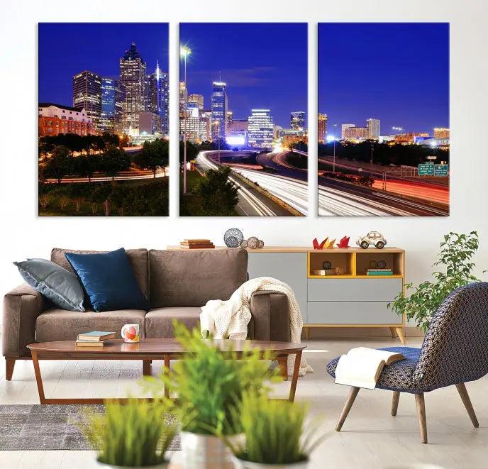 The living room features an Atlanta City Lights Night Blue Skyline canvas print on the wall. This museum-quality triptych showcases a highway and skyscrapers at night, comes with a UV-protective coating, and is ready to hang, adding both elegance and ease to your space.