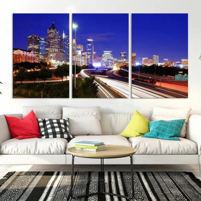 The living room features an Atlanta City Lights Night Blue Skyline canvas print on the wall. This museum-quality triptych showcases a highway and skyscrapers at night, comes with a UV-protective coating, and is ready to hang, adding both elegance and ease to your space.