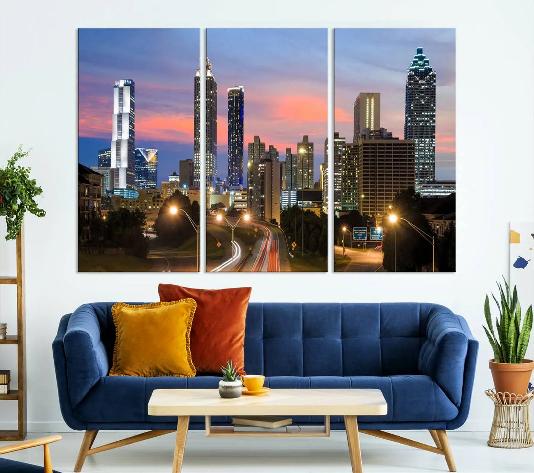 The Atlanta City Lights Sunset Skyline Cityscape View Wall Art Canvas Print is showcased in a modern living room. This artwork is gallery-wrapped on museum-quality canvas and features a UV-protective coating to maintain its vibrant colors.