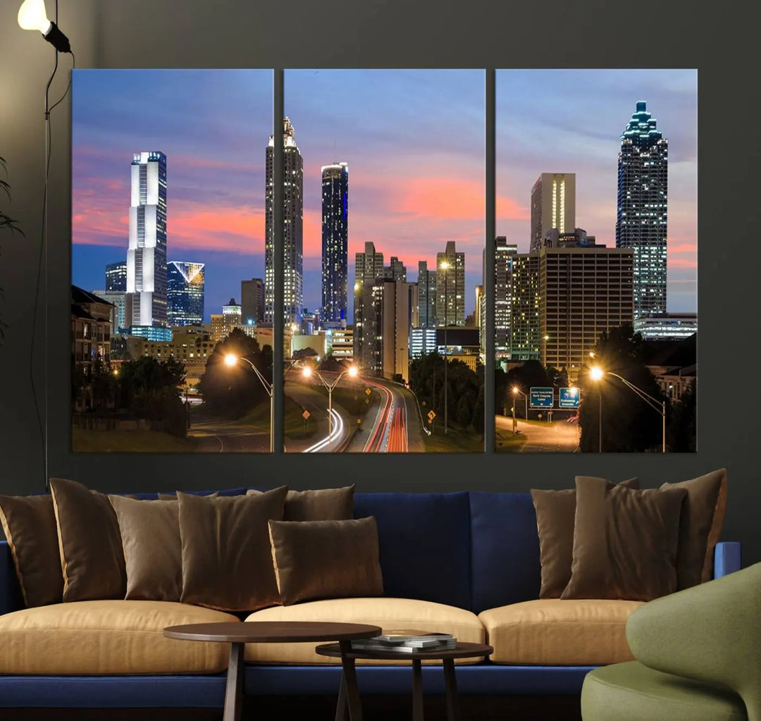 The Atlanta City Lights Sunset Skyline Cityscape View Wall Art Canvas Print is showcased in a modern living room. This artwork is gallery-wrapped on museum-quality canvas and features a UV-protective coating to maintain its vibrant colors.