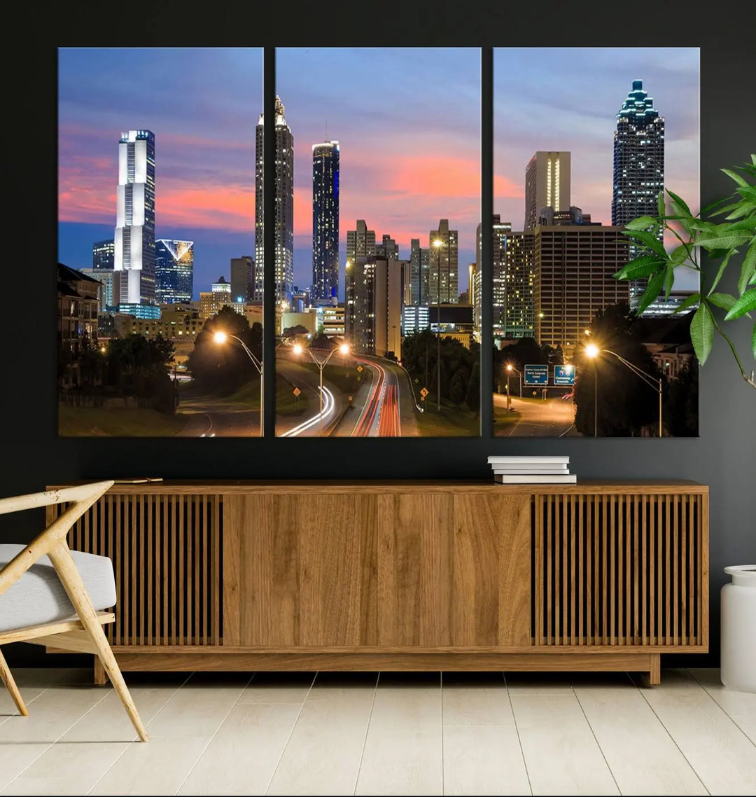 The Atlanta City Lights Sunset Skyline Cityscape View Wall Art Canvas Print is showcased in a modern living room. This artwork is gallery-wrapped on museum-quality canvas and features a UV-protective coating to maintain its vibrant colors.