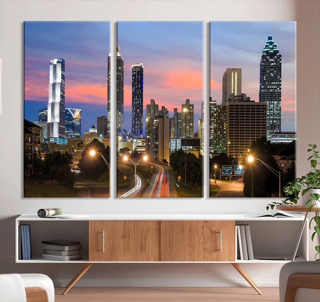 The Atlanta City Lights Sunset Skyline Cityscape View Wall Art Canvas Print is showcased in a modern living room. This artwork is gallery-wrapped on museum-quality canvas and features a UV-protective coating to maintain its vibrant colors.