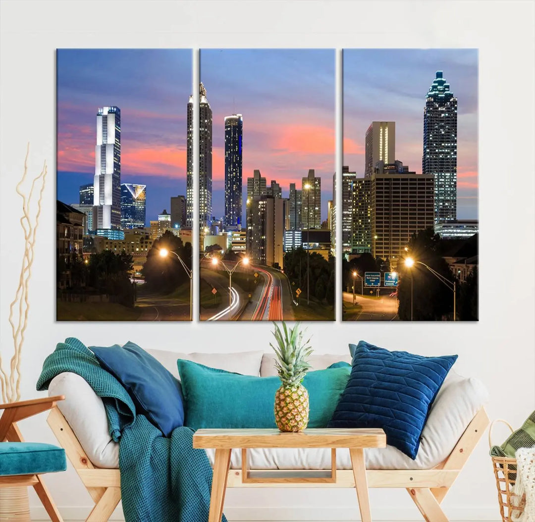 The Atlanta City Lights Sunset Skyline Cityscape View Wall Art Canvas Print is showcased in a modern living room. This artwork is gallery-wrapped on museum-quality canvas and features a UV-protective coating to maintain its vibrant colors.