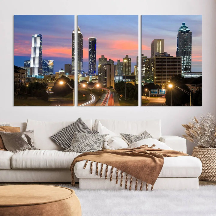 The Atlanta City Lights Sunset Skyline Cityscape View Wall Art Canvas Print is showcased in a modern living room. This artwork is gallery-wrapped on museum-quality canvas and features a UV-protective coating to maintain its vibrant colors.