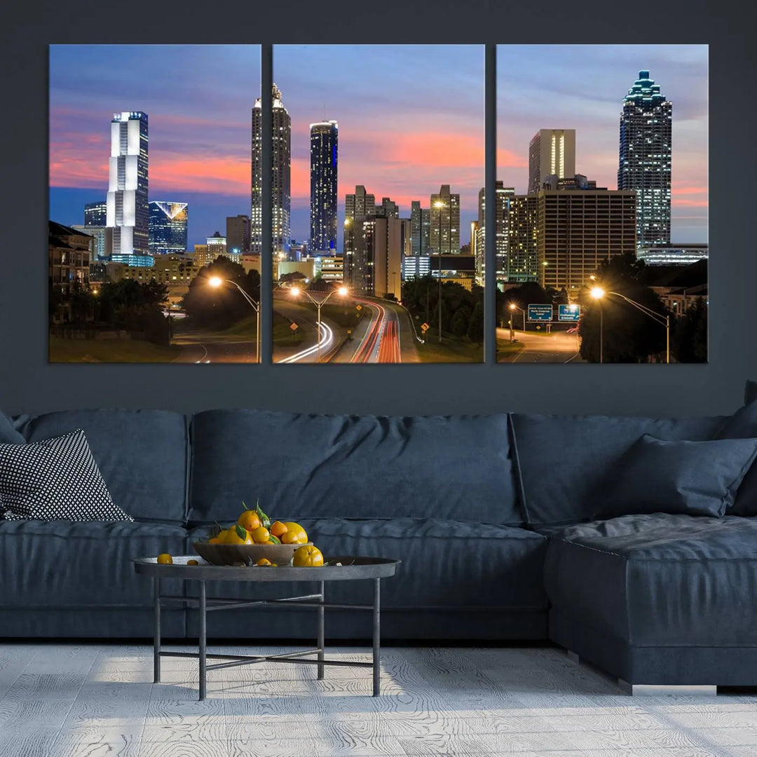 The Atlanta City Lights Sunset Skyline Cityscape View Wall Art Canvas Print is showcased in a modern living room. This artwork is gallery-wrapped on museum-quality canvas and features a UV-protective coating to maintain its vibrant colors.