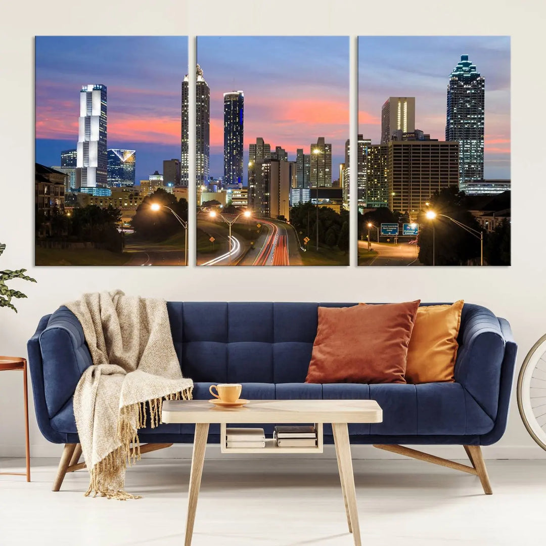 The Atlanta City Lights Sunset Skyline Cityscape View Wall Art Canvas Print is showcased in a modern living room. This artwork is gallery-wrapped on museum-quality canvas and features a UV-protective coating to maintain its vibrant colors.