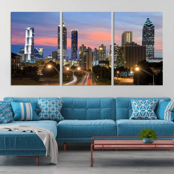 The Atlanta City Lights Sunset Skyline Cityscape View Wall Art Canvas Print is showcased in a modern living room. This artwork is gallery-wrapped on museum-quality canvas and features a UV-protective coating to maintain its vibrant colors.