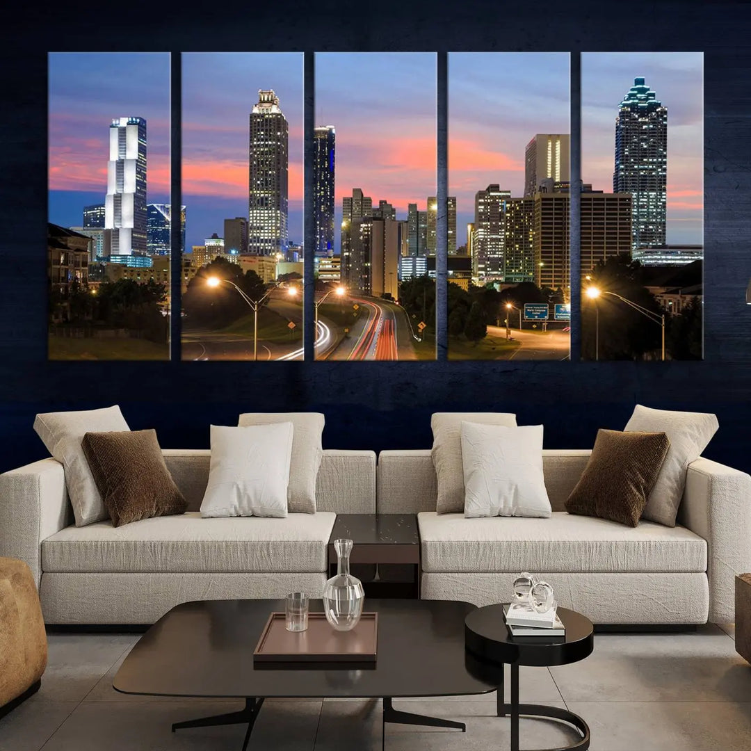 The Atlanta City Lights Sunset Skyline Cityscape View Wall Art Canvas Print is showcased in a modern living room. This artwork is gallery-wrapped on museum-quality canvas and features a UV-protective coating to maintain its vibrant colors.