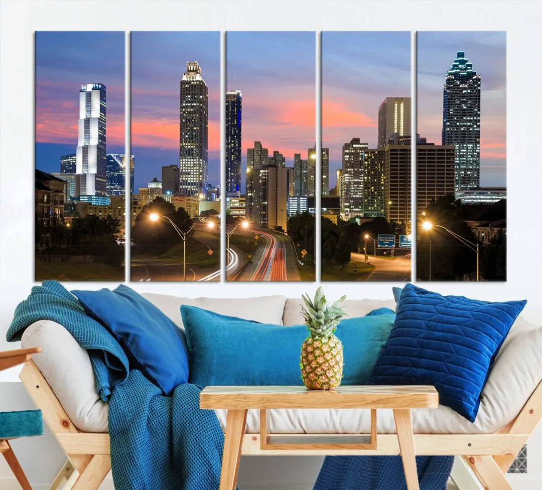 The Atlanta City Lights Sunset Skyline Cityscape View Wall Art Canvas Print is showcased in a modern living room. This artwork is gallery-wrapped on museum-quality canvas and features a UV-protective coating to maintain its vibrant colors.