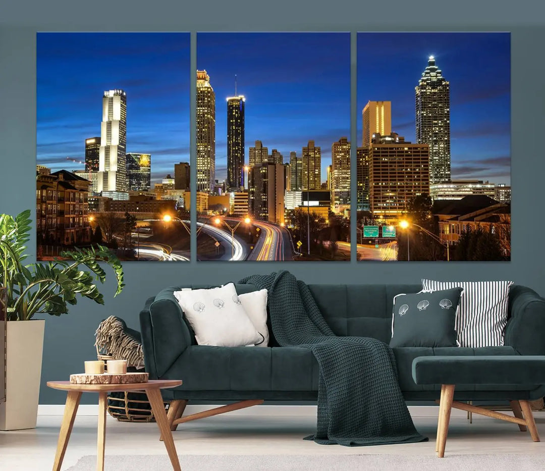 A modern living room is enhanced by the "Atlanta Cityscape View Wall Art Canvas Print" displayed as a triptych on museum-quality canvas. The hand-assembled framed art adds sophistication, crafting an inviting atmosphere. Complete your stylish space effortlessly with free shipping.