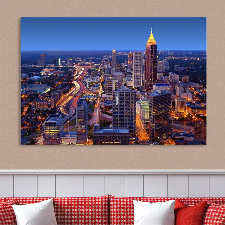 The triptych titled "Atlanta Wall Art Canvas Print" decorates the wall in a modern living room. This museum-quality artwork of a cityscape at night is ready to hang and features a UV-protective coating that ensures lasting vibrancy and elegance.