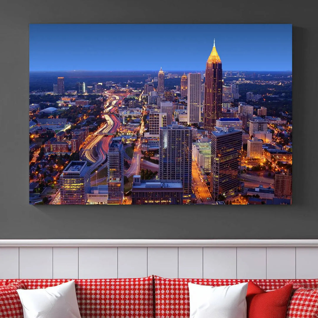 The triptych titled "Atlanta Wall Art Canvas Print" decorates the wall in a modern living room. This museum-quality artwork of a cityscape at night is ready to hang and features a UV-protective coating that ensures lasting vibrancy and elegance.