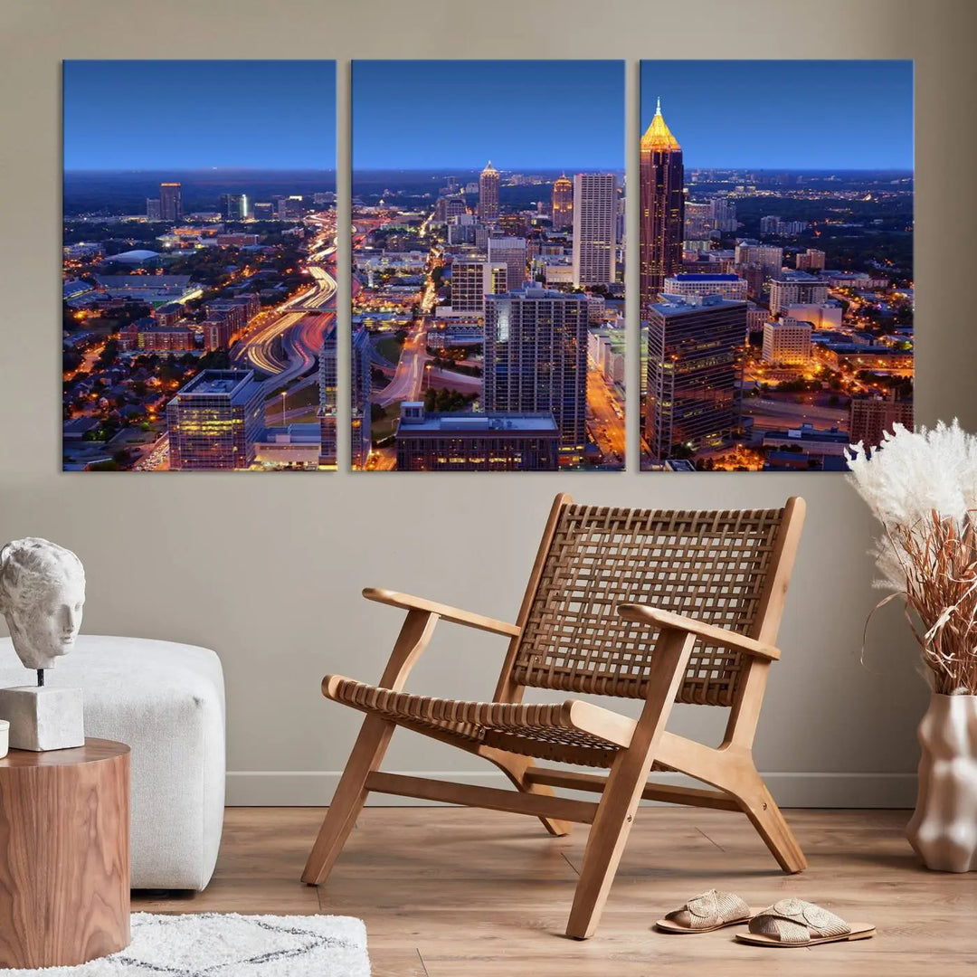 The triptych titled "Atlanta Wall Art Canvas Print" decorates the wall in a modern living room. This museum-quality artwork of a cityscape at night is ready to hang and features a UV-protective coating that ensures lasting vibrancy and elegance.