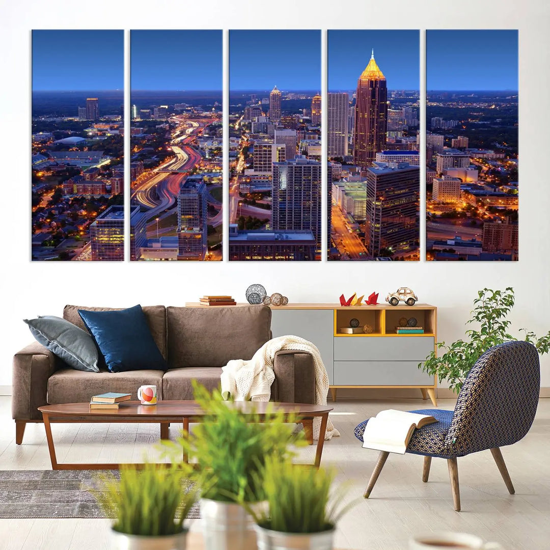 The triptych titled "Atlanta Wall Art Canvas Print" decorates the wall in a modern living room. This museum-quality artwork of a cityscape at night is ready to hang and features a UV-protective coating that ensures lasting vibrancy and elegance.