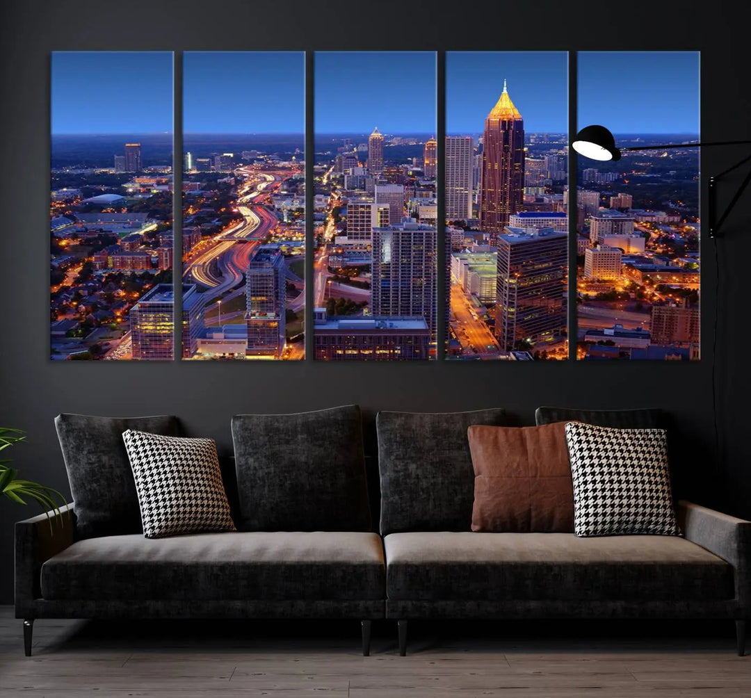 The triptych titled "Atlanta Wall Art Canvas Print" decorates the wall in a modern living room. This museum-quality artwork of a cityscape at night is ready to hang and features a UV-protective coating that ensures lasting vibrancy and elegance.