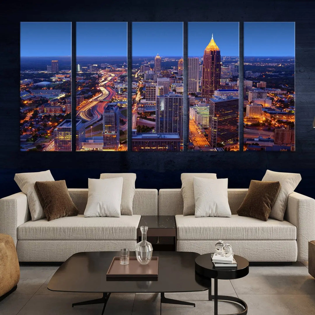 The triptych titled "Atlanta Wall Art Canvas Print" decorates the wall in a modern living room. This museum-quality artwork of a cityscape at night is ready to hang and features a UV-protective coating that ensures lasting vibrancy and elegance.