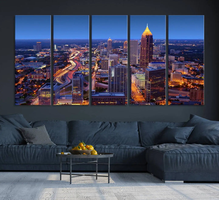 The triptych titled "Atlanta Wall Art Canvas Print" decorates the wall in a modern living room. This museum-quality artwork of a cityscape at night is ready to hang and features a UV-protective coating that ensures lasting vibrancy and elegance.