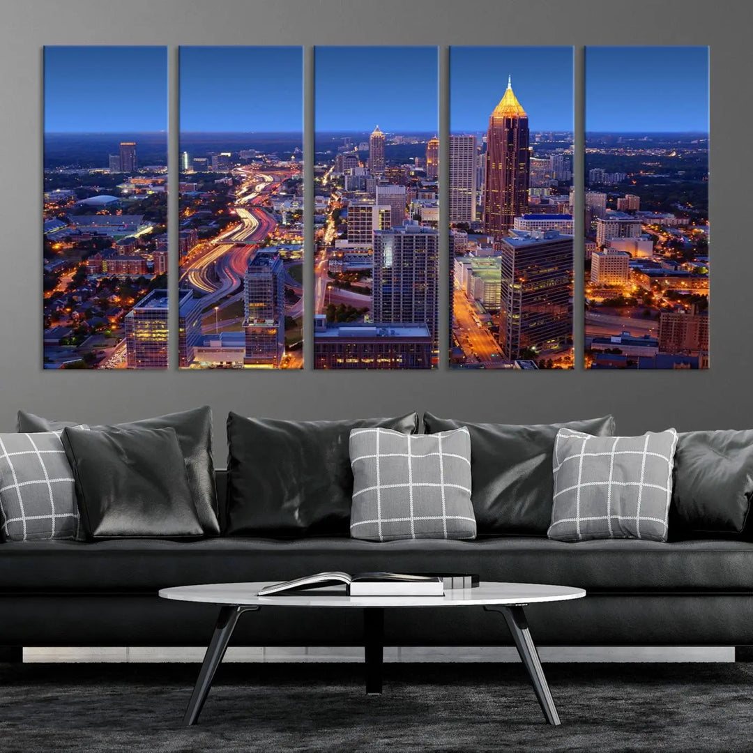 The triptych titled "Atlanta Wall Art Canvas Print" decorates the wall in a modern living room. This museum-quality artwork of a cityscape at night is ready to hang and features a UV-protective coating that ensures lasting vibrancy and elegance.