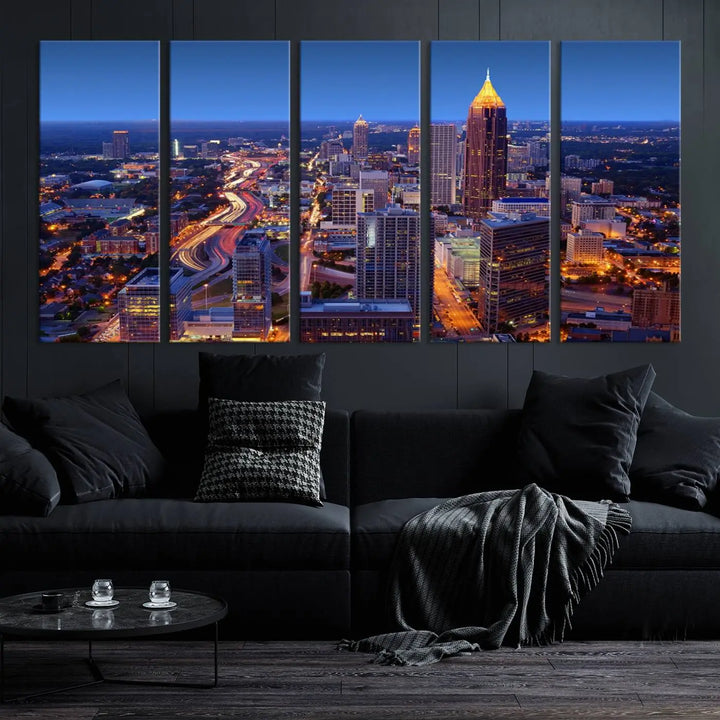 The triptych titled "Atlanta Wall Art Canvas Print" decorates the wall in a modern living room. This museum-quality artwork of a cityscape at night is ready to hang and features a UV-protective coating that ensures lasting vibrancy and elegance.