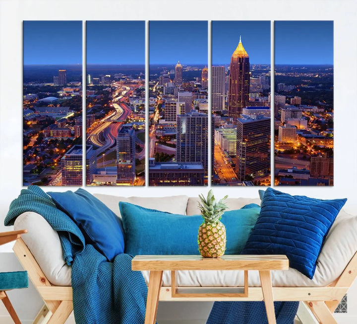 The triptych titled "Atlanta Wall Art Canvas Print" decorates the wall in a modern living room. This museum-quality artwork of a cityscape at night is ready to hang and features a UV-protective coating that ensures lasting vibrancy and elegance.