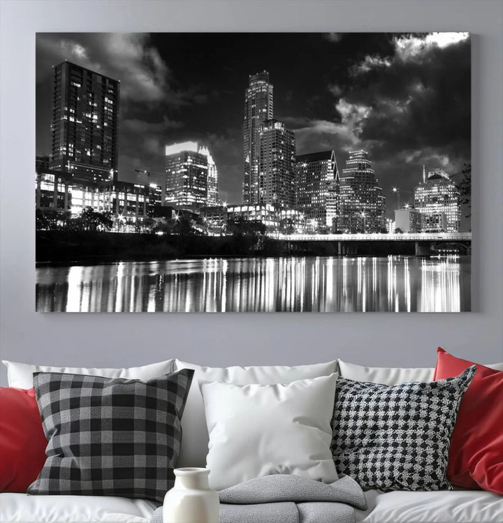 The Austin City Lights Cloudy Skyline Black and White Wall Art Cityscape Canvas Print is a large triptych that showcases illuminated city buildings reflected in water at night. This artwork is produced on museum-quality canvases with a UV-protective coating, ensuring its vibrancy and longevity for years to come.