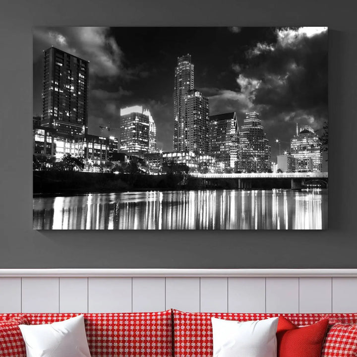 The Austin City Lights Cloudy Skyline Black and White Wall Art Cityscape Canvas Print is a large triptych that showcases illuminated city buildings reflected in water at night. This artwork is produced on museum-quality canvases with a UV-protective coating, ensuring its vibrancy and longevity for years to come.