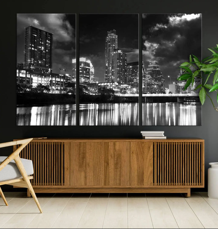 The Austin City Lights Cloudy Skyline Black and White Wall Art Cityscape Canvas Print is a large triptych that showcases illuminated city buildings reflected in water at night. This artwork is produced on museum-quality canvases with a UV-protective coating, ensuring its vibrancy and longevity for years to come.