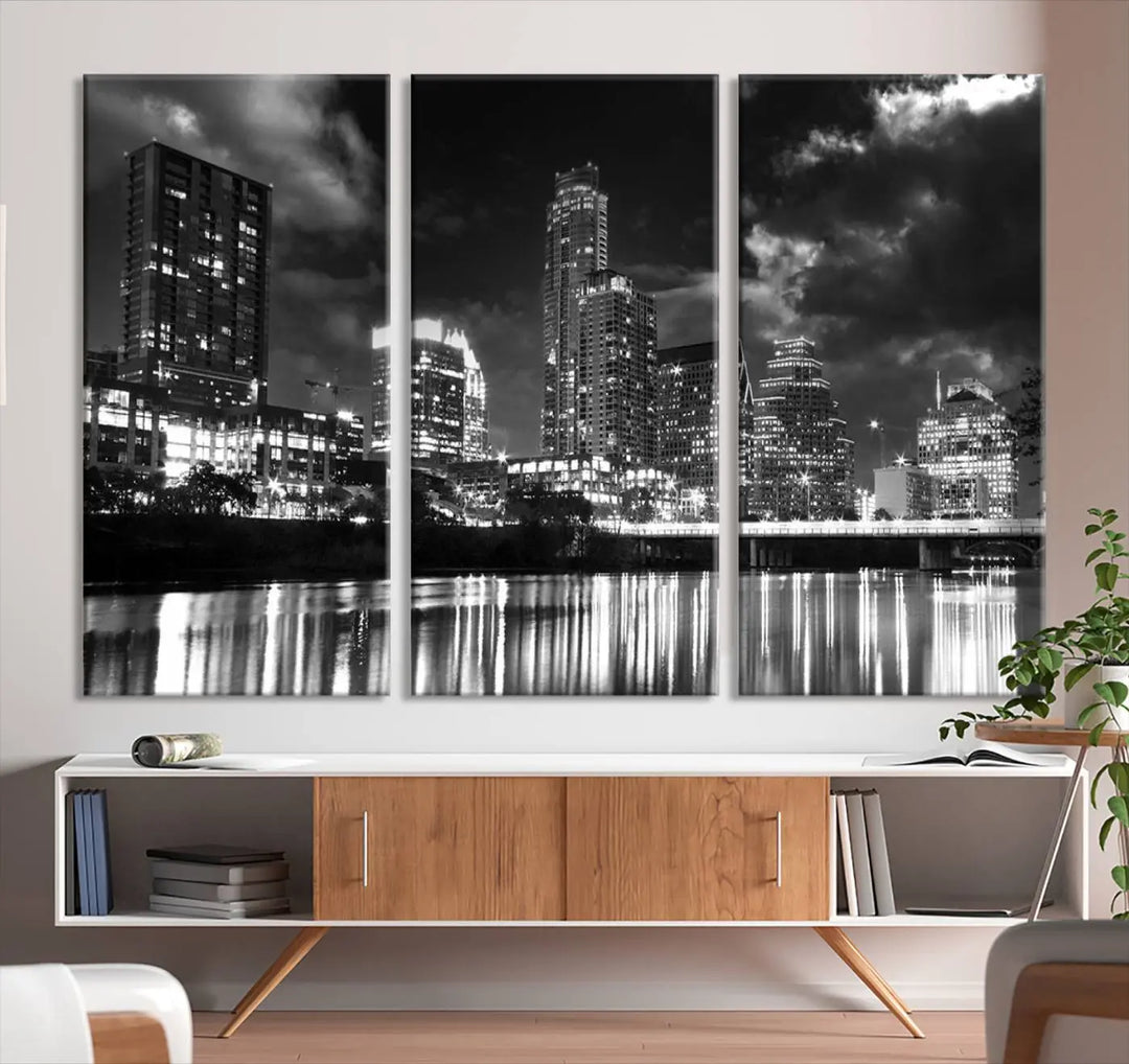 The Austin City Lights Cloudy Skyline Black and White Wall Art Cityscape Canvas Print is a large triptych that showcases illuminated city buildings reflected in water at night. This artwork is produced on museum-quality canvases with a UV-protective coating, ensuring its vibrancy and longevity for years to come.