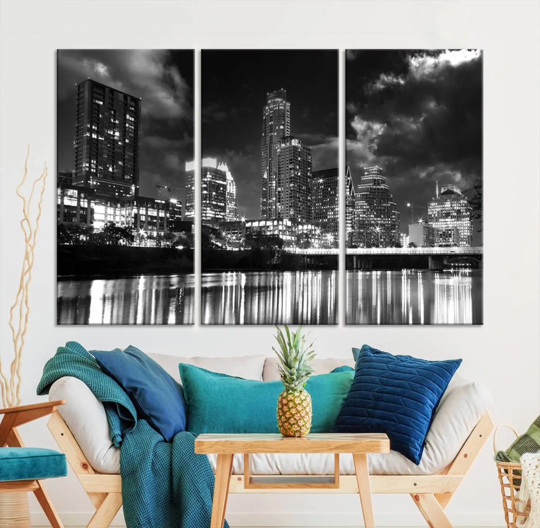 The Austin City Lights Cloudy Skyline Black and White Wall Art Cityscape Canvas Print is a large triptych that showcases illuminated city buildings reflected in water at night. This artwork is produced on museum-quality canvases with a UV-protective coating, ensuring its vibrancy and longevity for years to come.