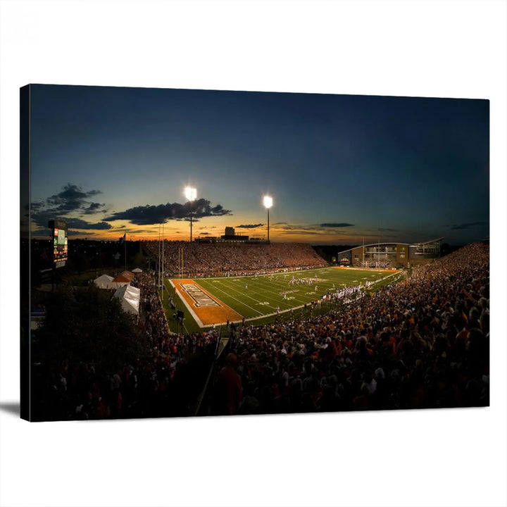 Experience the vibrant energy of game day with the Ball State Cardinals Football Team Print - Muncie Scheumann Stadium Wall Art Canvas Print. This stunning artwork captures a sunset-lit football stadium, alive with a match in progress and spectators filling the stands under floodlights, all rendered on museum-quality canvas.