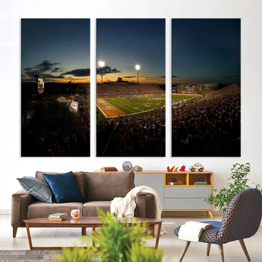 Experience the vibrant energy of game day with the Ball State Cardinals Football Team Print - Muncie Scheumann Stadium Wall Art Canvas Print. This stunning artwork captures a sunset-lit football stadium, alive with a match in progress and spectators filling the stands under floodlights, all rendered on museum-quality canvas.