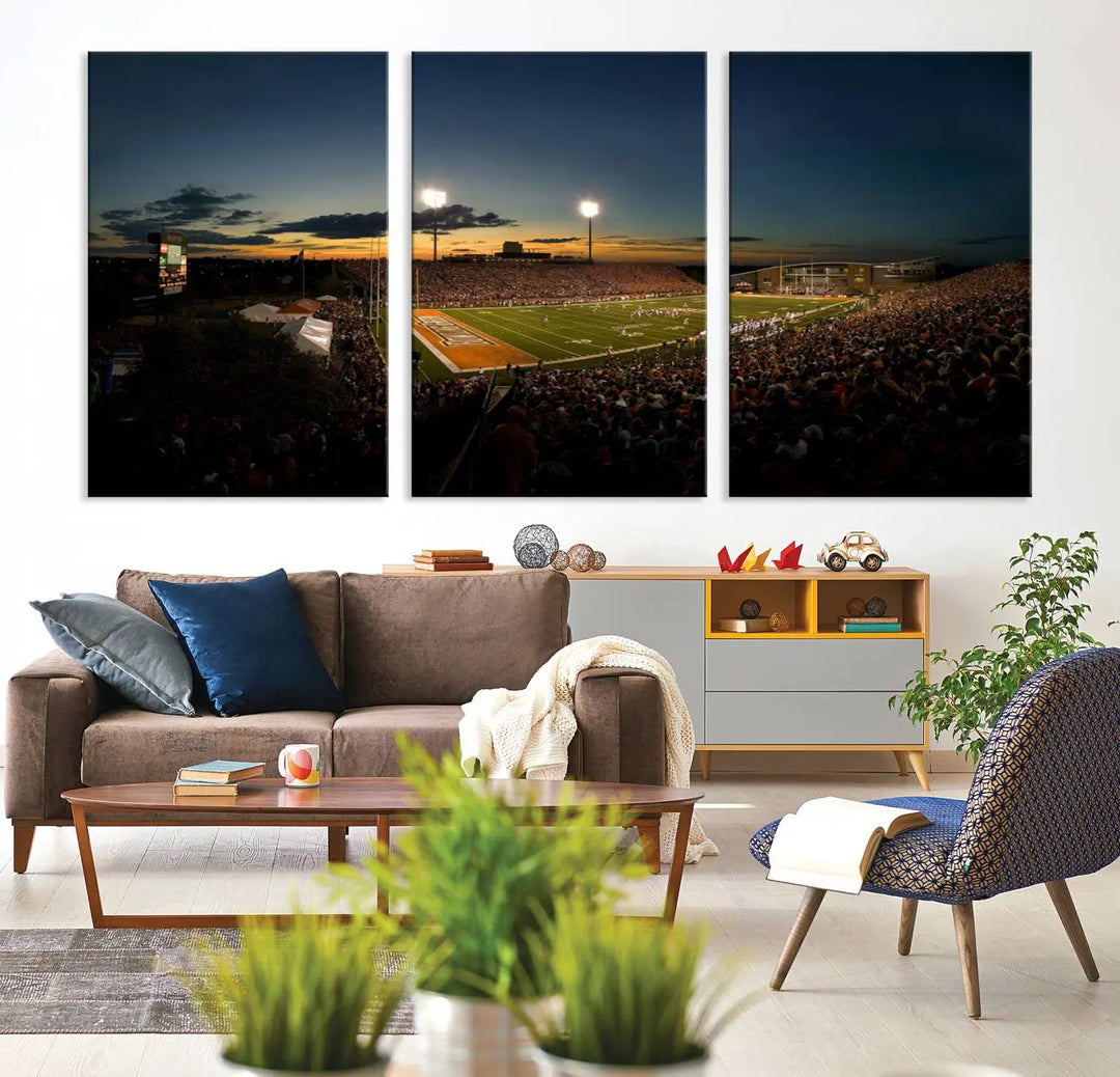 Experience the vibrant energy of game day with the Ball State Cardinals Football Team Print - Muncie Scheumann Stadium Wall Art Canvas Print. This stunning artwork captures a sunset-lit football stadium, alive with a match in progress and spectators filling the stands under floodlights, all rendered on museum-quality canvas.