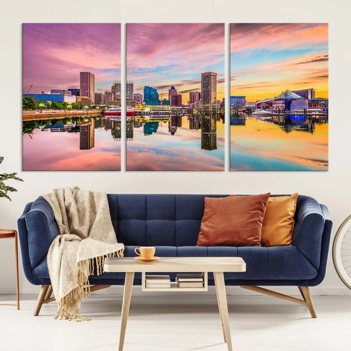 The Baltimore City Lights Sunset Pink and Orange Skyline canvas print depicts a vibrant cityscape at sunset, with skyscrapers reflecting in a calm river on museum-quality canvas. Each piece is gallery wrapped and features a UV-protective coating.