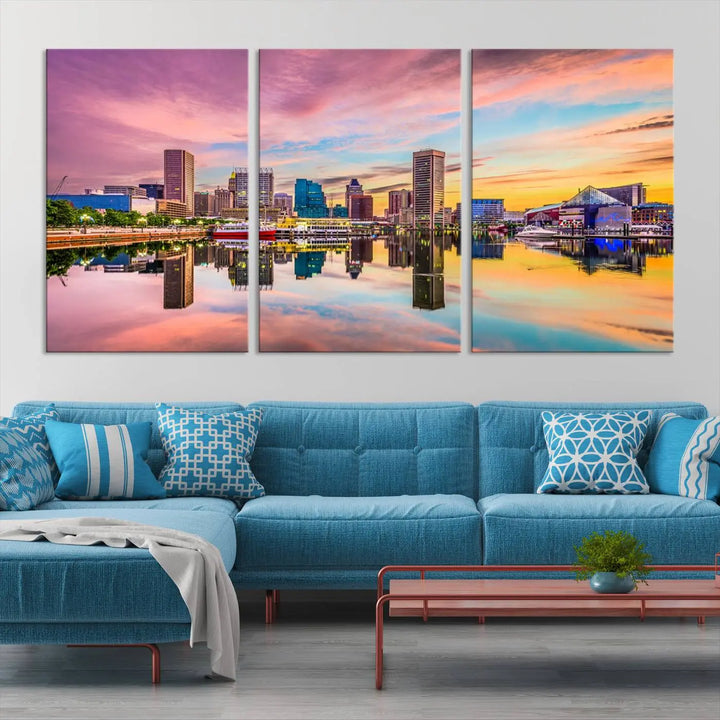 The Baltimore City Lights Sunset Pink and Orange Skyline canvas print depicts a vibrant cityscape at sunset, with skyscrapers reflecting in a calm river on museum-quality canvas. Each piece is gallery wrapped and features a UV-protective coating.