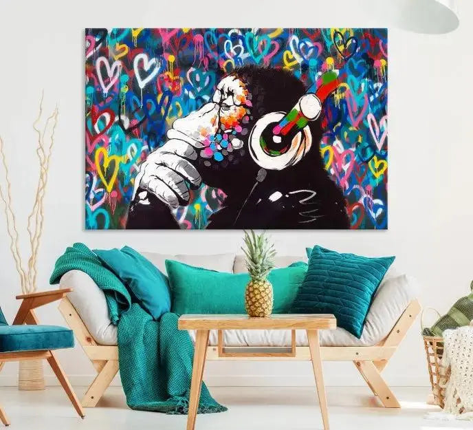 A triptych featuring the "Banksy Canvas Wall Art Thinking Monkey Canvas Art Print" showcases a chimp wearing headphones against a colorful heart-patterned background. Each museum-quality canvas is gallery wrapped and finished with a UV-protective coating to ensure lasting brilliance.