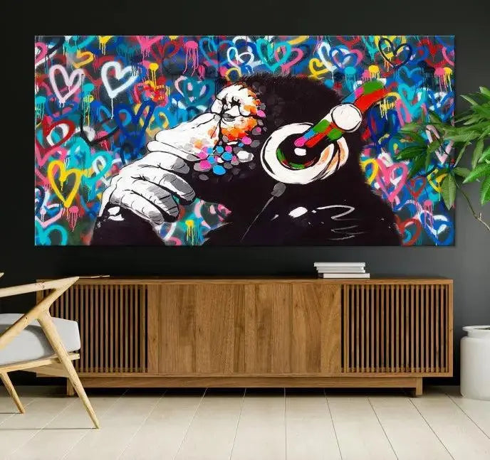 A triptych featuring the "Banksy Canvas Wall Art Thinking Monkey Canvas Art Print" showcases a chimp wearing headphones against a colorful heart-patterned background. Each museum-quality canvas is gallery wrapped and finished with a UV-protective coating to ensure lasting brilliance.