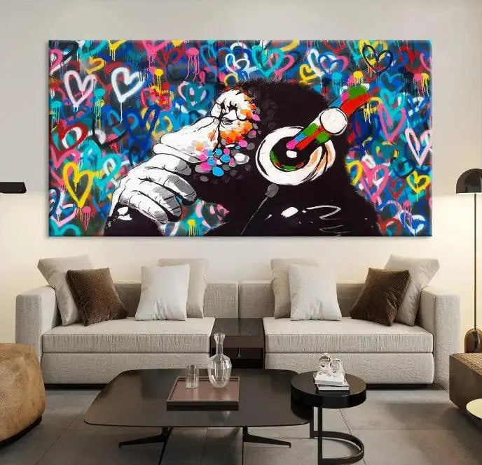 A triptych featuring the "Banksy Canvas Wall Art Thinking Monkey Canvas Art Print" showcases a chimp wearing headphones against a colorful heart-patterned background. Each museum-quality canvas is gallery wrapped and finished with a UV-protective coating to ensure lasting brilliance.