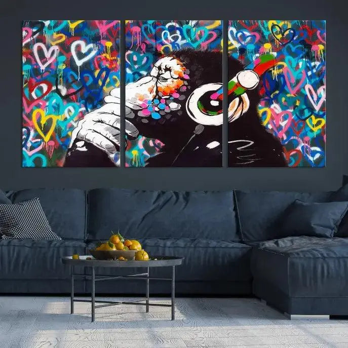 A triptych featuring the "Banksy Canvas Wall Art Thinking Monkey Canvas Art Print" showcases a chimp wearing headphones against a colorful heart-patterned background. Each museum-quality canvas is gallery wrapped and finished with a UV-protective coating to ensure lasting brilliance.