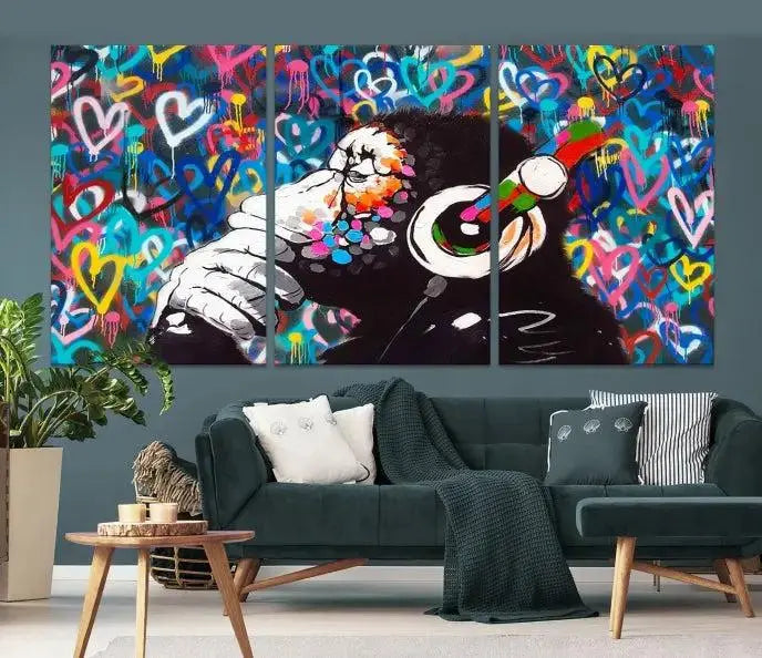 A triptych featuring the "Banksy Canvas Wall Art Thinking Monkey Canvas Art Print" showcases a chimp wearing headphones against a colorful heart-patterned background. Each museum-quality canvas is gallery wrapped and finished with a UV-protective coating to ensure lasting brilliance.