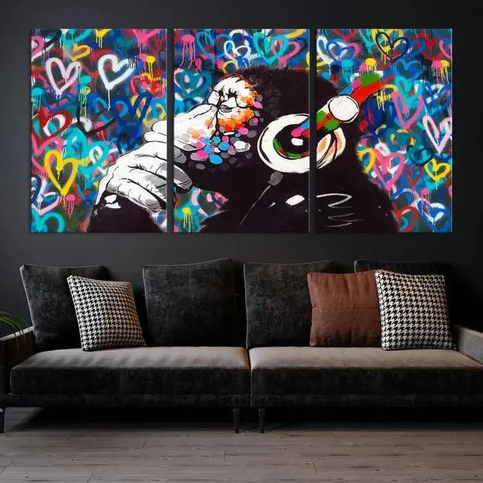 A triptych featuring the "Banksy Canvas Wall Art Thinking Monkey Canvas Art Print" showcases a chimp wearing headphones against a colorful heart-patterned background. Each museum-quality canvas is gallery wrapped and finished with a UV-protective coating to ensure lasting brilliance.