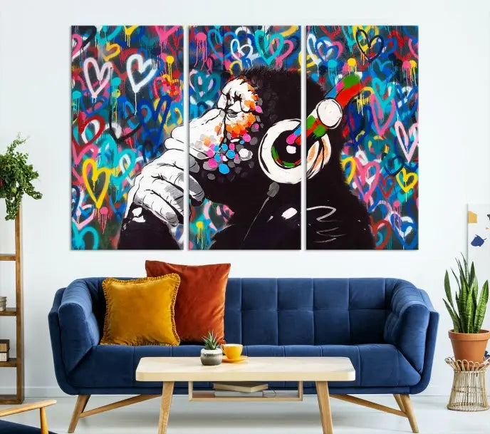 A triptych featuring the "Banksy Canvas Wall Art Thinking Monkey Canvas Art Print" showcases a chimp wearing headphones against a colorful heart-patterned background. Each museum-quality canvas is gallery wrapped and finished with a UV-protective coating to ensure lasting brilliance.