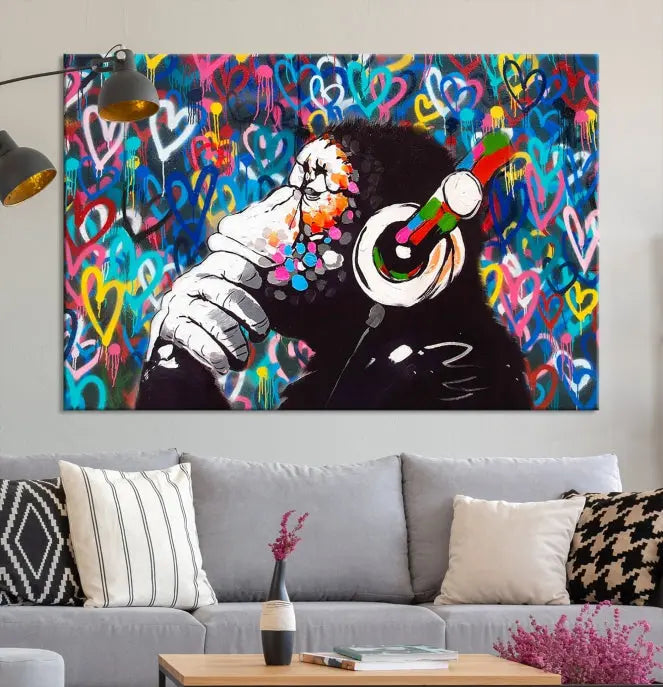 A triptych featuring the "Banksy Canvas Wall Art Thinking Monkey Canvas Art Print" showcases a chimp wearing headphones against a colorful heart-patterned background. Each museum-quality canvas is gallery wrapped and finished with a UV-protective coating to ensure lasting brilliance.