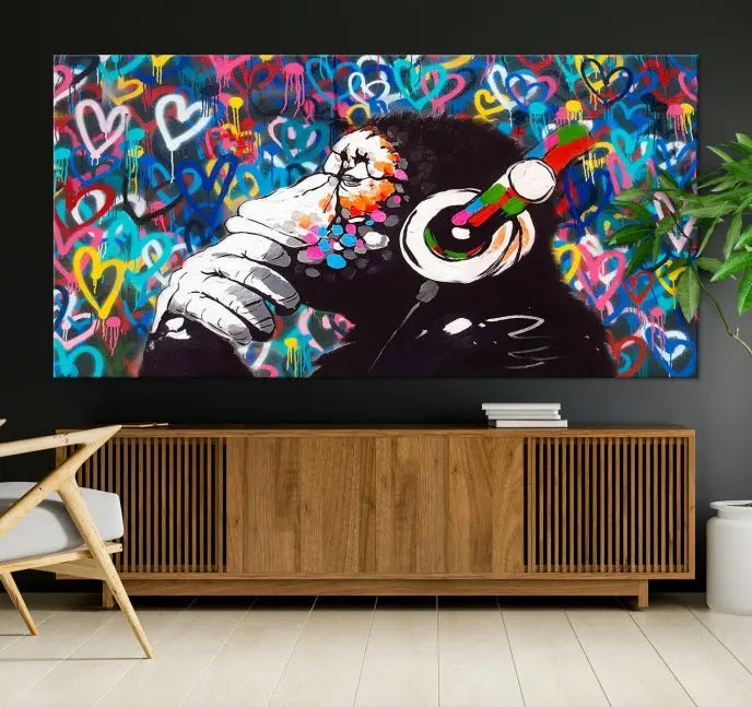 A triptych featuring the "Banksy Canvas Wall Art Thinking Monkey Canvas Art Print" showcases a chimp wearing headphones against a colorful heart-patterned background. Each museum-quality canvas is gallery wrapped and finished with a UV-protective coating to ensure lasting brilliance.