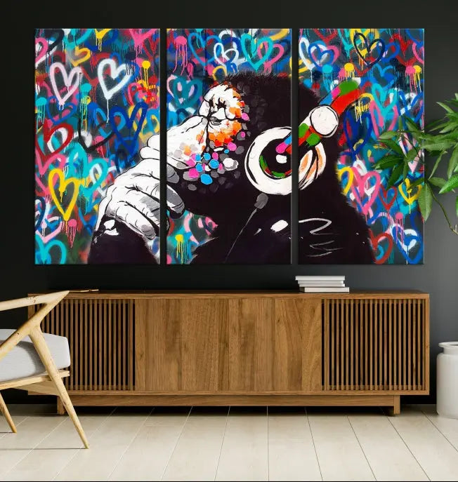 A triptych featuring the "Banksy Canvas Wall Art Thinking Monkey Canvas Art Print" showcases a chimp wearing headphones against a colorful heart-patterned background. Each museum-quality canvas is gallery wrapped and finished with a UV-protective coating to ensure lasting brilliance.