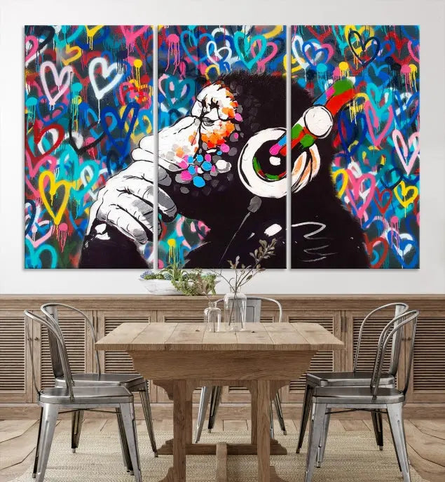 A triptych featuring the "Banksy Canvas Wall Art Thinking Monkey Canvas Art Print" showcases a chimp wearing headphones against a colorful heart-patterned background. Each museum-quality canvas is gallery wrapped and finished with a UV-protective coating to ensure lasting brilliance.