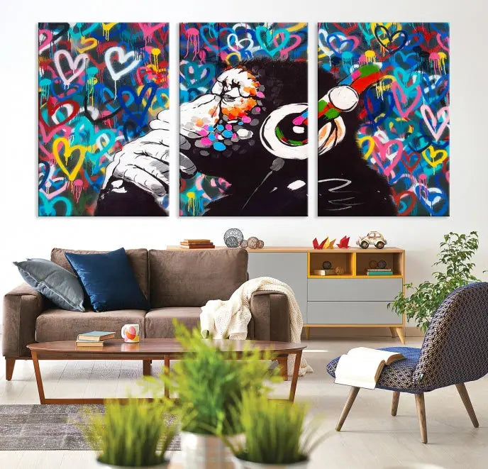 A triptych featuring the "Banksy Canvas Wall Art Thinking Monkey Canvas Art Print" showcases a chimp wearing headphones against a colorful heart-patterned background. Each museum-quality canvas is gallery wrapped and finished with a UV-protective coating to ensure lasting brilliance.