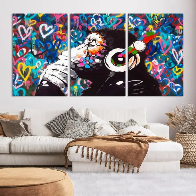 A triptych featuring the "Banksy Canvas Wall Art Thinking Monkey Canvas Art Print" showcases a chimp wearing headphones against a colorful heart-patterned background. Each museum-quality canvas is gallery wrapped and finished with a UV-protective coating to ensure lasting brilliance.