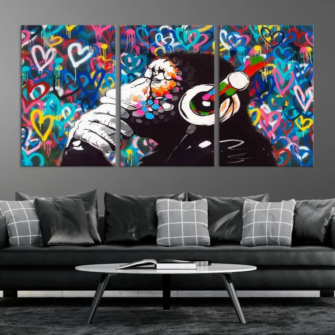 A triptych featuring the "Banksy Canvas Wall Art Thinking Monkey Canvas Art Print" showcases a chimp wearing headphones against a colorful heart-patterned background. Each museum-quality canvas is gallery wrapped and finished with a UV-protective coating to ensure lasting brilliance.