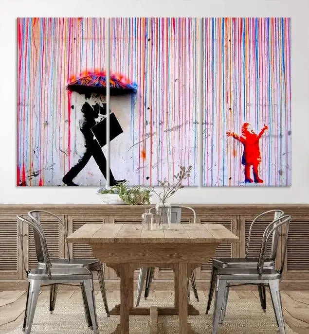 Introducing the Banksy Street Art Wall Art Canvas Print, a captivating piece featuring modern art of a man with an umbrella while a child reaches up through vibrant drips. Its premium canvas and gallery-quality finish make it an eye-catching addition to any space.